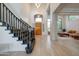 Grand entryway featuring high ceilings, hardwood floors, and a staircase with black banister at 10843 E Acacia Dr, Scottsdale, AZ 85255