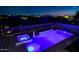 Nighttime view of a pool and jacuzzi with views of city lights at 10843 E Acacia Dr, Scottsdale, AZ 85255