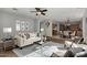 Spacious living room with plush seating, ceiling fan, modern decor, and open layout to the kitchen at 12048 N 146Th Ave, Surprise, AZ 85379