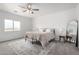 Well-lit bedroom with neutral tones, a large window, ceiling fan, and a comfortable bed with soft patterned linens at 6515 N Loma Ct, Casa Grande, AZ 85194