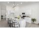 Bright kitchen features white cabinetry, stainless steel appliances, an island with bar seating, and sleek countertops at 6515 N Loma Ct, Casa Grande, AZ 85194