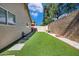 A backyard features artificial turf, stepping stones, and low-maintenance desert landscaping with privacy fencing at 8972 E Arizona Park Pl, Scottsdale, AZ 85260