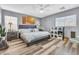 Comfortable bedroom with wood-look flooring, large bed, and scenic forest art at 8972 E Arizona Park Pl, Scottsdale, AZ 85260
