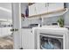 Functional laundry room featuring a modern washer and dryer set, storage cabinets, and wood-style flooring at 8972 E Arizona Park Pl, Scottsdale, AZ 85260