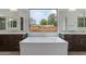 Spa-like bathroom featuring a soaking tub, dual vanities, and an outside view at 100 W Northern Ave # 15, Phoenix, AZ 85021