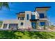 Modern two-story home featuring a stucco facade, black trim, a glass garage door, and landscaped yard at 100 W Northern Ave # 15, Phoenix, AZ 85021
