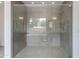 Modern glass enclosed shower with gray tiled walls and a shower head with a window view at 100 W Northern Ave # 15, Phoenix, AZ 85021