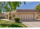 Charming home exterior features a well-manicured lawn and a two-car garage, and mature landscaping at 10461 W Hutton Dr, Sun City, AZ 85351