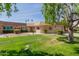 Well-maintained front yard features lush green grass and decorative bushes, enhancing the curb appeal at 10461 W Hutton Dr, Sun City, AZ 85351