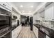 Modern kitchen featuring white cabinetry, black countertops, stainless steel appliances and adjacent dining area at 10461 W Hutton Dr, Sun City, AZ 85351