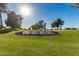 Community landscaping is well maintained with mature trees and bright green grass at 10461 W Hutton Dr, Sun City, AZ 85351
