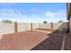 An open backyard features a stone ground cover, a block wall, and a partially raised platform at 1057 W Mesquite Ave, Apache Junction, AZ 85120