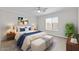 Staged bedroom features neutral color palette, king sized bed, ample natural light from large window at 1057 W Mesquite Ave, Apache Junction, AZ 85120