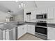 Updated kitchen features stainless steel appliances, gray countertops, painted brick accent wall and ample cabinet space at 1057 W Mesquite Ave, Apache Junction, AZ 85120