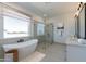 Luxurious bathroom features a freestanding soaking tub, glass-enclosed shower, and double vanity with modern fixtures at 10829 W Woodruff Rd, Casa Grande, AZ 85194