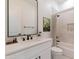 Well-lit bathroom featuring a single sink vanity, decorative mirror, and a shower with a shower curtain at 10829 W Woodruff Rd, Casa Grande, AZ 85194