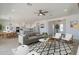 Bright, open-concept living room features a modern ceiling fan and flows seamlessly into the kitchen and dining area at 10829 W Woodruff Rd, Casa Grande, AZ 85194