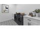Bright laundry room featuring modern appliances, white cabinetry, and stylish patterned tile flooring at 10907 W Woodruff Rd, Casa Grande, AZ 85194