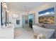 Luxurious bathroom featuring a soaking tub, a frameless glass shower, dual vanities, and elegant tile work at 10947 W Woodruff Rd, Casa Grande, AZ 85194