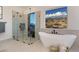 Elegant bathroom featuring a freestanding tub, glass-enclosed shower, and neutral tile for a spa-like experience at 10947 W Woodruff Rd, Casa Grande, AZ 85194