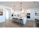 Modern white kitchen with an island, pendant lighting, stainless steel appliances, and breakfast bar with seating at 10947 W Woodruff Rd, Casa Grande, AZ 85194