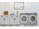 Well-equipped laundry room with front loading washer and dryer, a quartz countertop, and decorative tile flooring at 10947 W Woodruff Rd, Casa Grande, AZ 85194