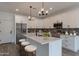Bright kitchen featuring white cabinets, stainless steel appliances, a quartz island and pendant lighting at 10981 W Woodruff Rd, Casa Grande, AZ 85194
