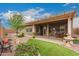 Inviting covered patio and backyard with mature landscaping, offering a serene outdoor living space at 11055 E Ocaso Ave, Mesa, AZ 85212