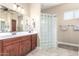 Bright bathroom featuring double sinks, vanity, a glass block shower, and contemporary lighting at 11055 E Ocaso Ave, Mesa, AZ 85212