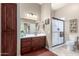 Well-lit bathroom with a dark wood vanity, a large mirror, and a glass-enclosed shower at 11055 E Ocaso Ave, Mesa, AZ 85212