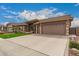 Charming home featuring manicured landscaping, a three-car garage, and a welcoming entryway at 11055 E Ocaso Ave, Mesa, AZ 85212