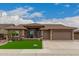 Charming home featuring manicured landscaping, a three-car garage, and a welcoming entryway at 11055 E Ocaso Ave, Mesa, AZ 85212