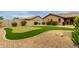 Backyard featuring a well-maintained putting green, desert landscaping, and mature shrubbery at 11277 W Buchanan St, Avondale, AZ 85323