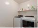 Well-equipped laundry room with modern, front-loading washer and dryer and shelving at 11277 W Buchanan St, Avondale, AZ 85323