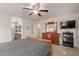 A comfortable carpeted main bedroom is complete with a ceiling fan, dresser, and TV at 11277 W Buchanan St, Avondale, AZ 85323