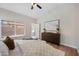 Bright bedroom features stylish decor, wood floors, large window and a ceiling fan at 116 W Jasper Dr, Gilbert, AZ 85233