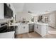 Bright kitchen with stainless steel appliances, white cabinets, and an eat-in bar overlooking the dining area and living room at 116 W Jasper Dr, Gilbert, AZ 85233