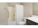 Bathroom features a bathtub with a shower curtain, toilet, and vanity with wood cabinets at 12047 W Red Hawk Dr, Peoria, AZ 85383