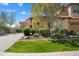 Charming home featuring a well-manicured lawn and a beautiful tree in the front yard at 12047 W Red Hawk Dr, Peoria, AZ 85383