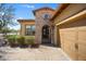 Close-up view of a tan home with stone accents and a brick driveway entrance at 12047 W Red Hawk Dr, Peoria, AZ 85383