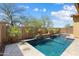 Beautiful backyard with a sparkling pool, stone accents, and mature landscaping at 12047 W Red Hawk Dr, Peoria, AZ 85383
