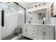 Bathroom with a dual sink vanity, an updated shower, and a decorative lighting fixture at 12415 N 41St Dr, Phoenix, AZ 85029