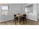 Bright dining area with a modern table set, minimalist decor, and warm wood-look flooring at 12415 N 41St Dr, Phoenix, AZ 85029