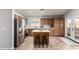 Kitchen area features a center island, stainless steel appliances, and wood-look tile flooring at 12415 N 41St Dr, Phoenix, AZ 85029