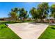 Community basketball court surrounded by lush green grass and mature trees, offering a recreational space for friendly games at 1344 N Constellation Way, Gilbert, AZ 85234
