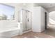 Well-lit bathroom features a soaking tub and separate glass shower with bright neutral color scheme at 1344 N Constellation Way, Gilbert, AZ 85234