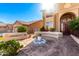 Stunning home featuring an arched entrance, elegant seating area, and beautiful desert landscaping at 1344 N Constellation Way, Gilbert, AZ 85234
