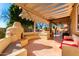 Spacious outdoor patio featuring a fireplace, outdoor kitchen, and ample seating under a pergola at 1344 N Constellation Way, Gilbert, AZ 85234