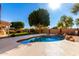 A pristine backyard pool with a rock waterfall feature and lush landscaping at 1344 N Constellation Way, Gilbert, AZ 85234