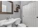 Well-maintained half-bathroom featuring a pedestal sink and white paneled door at 1391 E Angie St, Casa Grande, AZ 85122